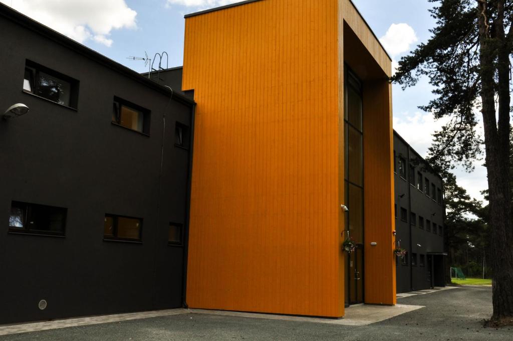 una puerta naranja en el lateral de un edificio en Männiku JK, en Tallin