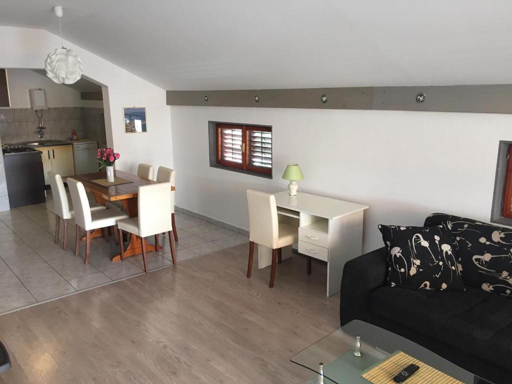 ein Wohnzimmer und eine Küche mit einem Sofa und einem Tisch in der Unterkunft Apartments Pavić in Betina