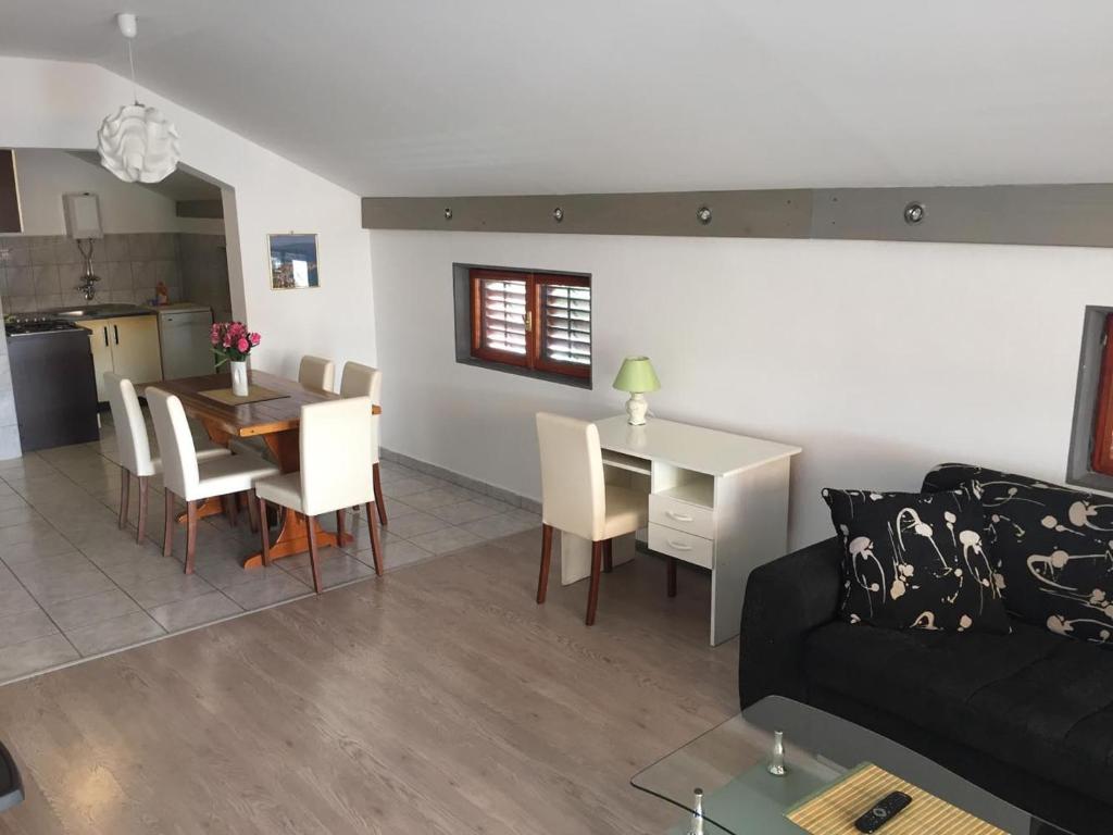 a living room and kitchen with a couch and a table at Apartments Pavić in Betina