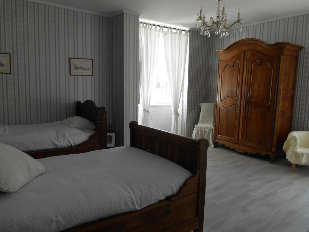 - une chambre avec 2 lits et une commode dans l'établissement Abbaye Laïque Le Bastion Labbadie, à Saint-Abit