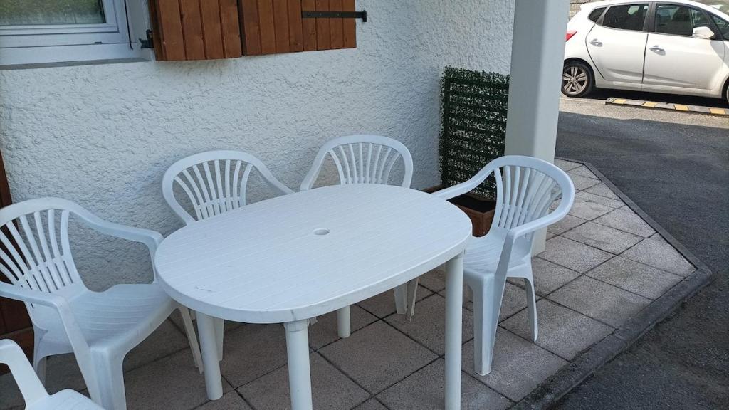 a white table and four white chairs on a sidewalk at Le cœur de ville in Thonon-les-Bains