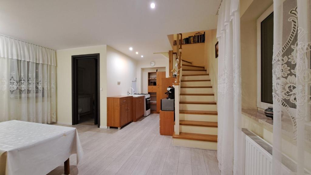 a hallway with a staircase and a room with a table at Dom przy Lawendowej Altanie in Kosow