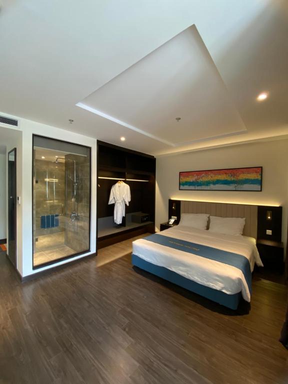a bedroom with a large bed and a sliding glass door at Căn hộ khách sạn Hạ Long Premier Sapphire in Ha Long