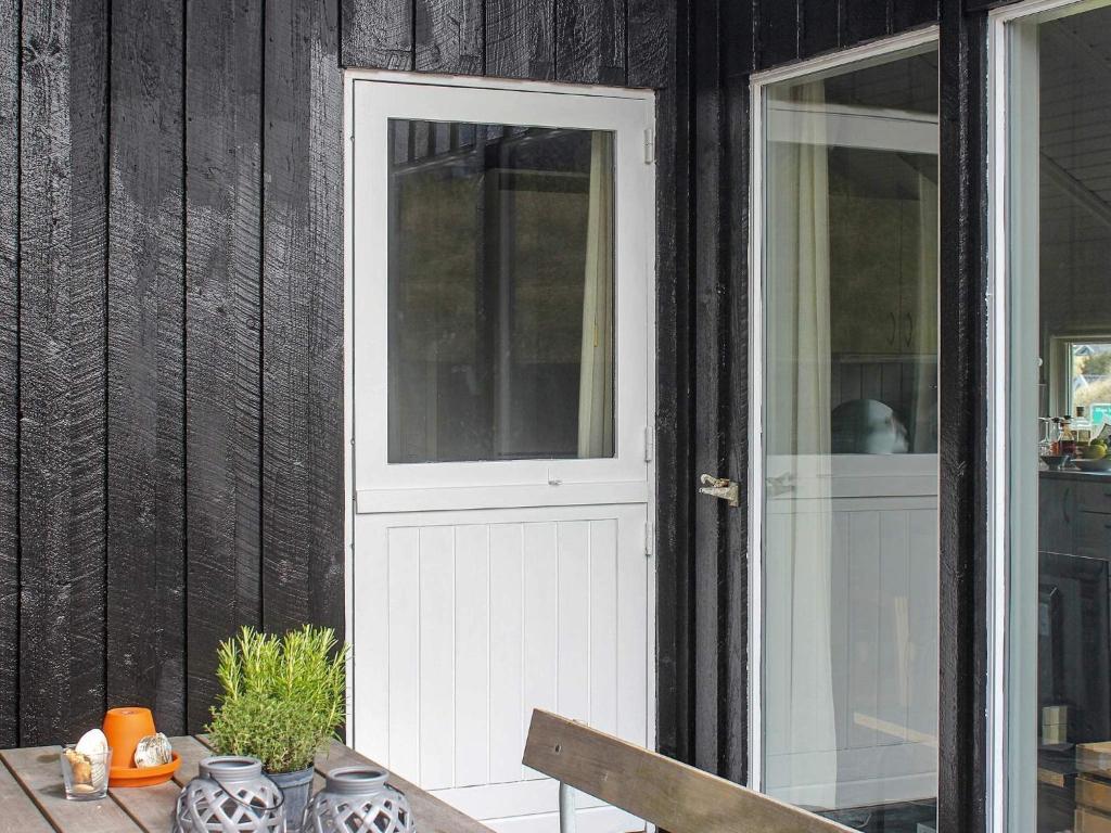a white door on a house with a table at Modern Beach House - By Traum Ferienwohnungen in Vejers Strand