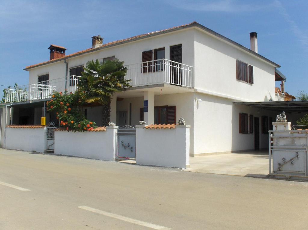 une maison blanche avec un palmier dans une rue dans l'établissement Apartments Ljubica, à Rovinj