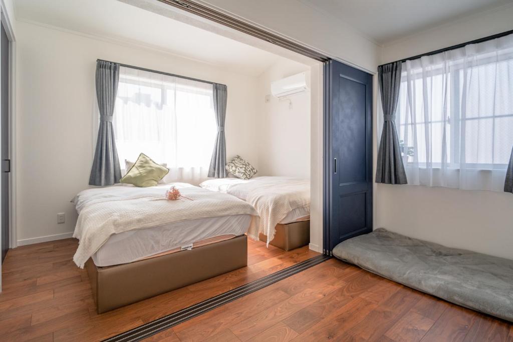 東京にある全新三之轮一户建a栋のベッド2台と大きな鏡のある寝室