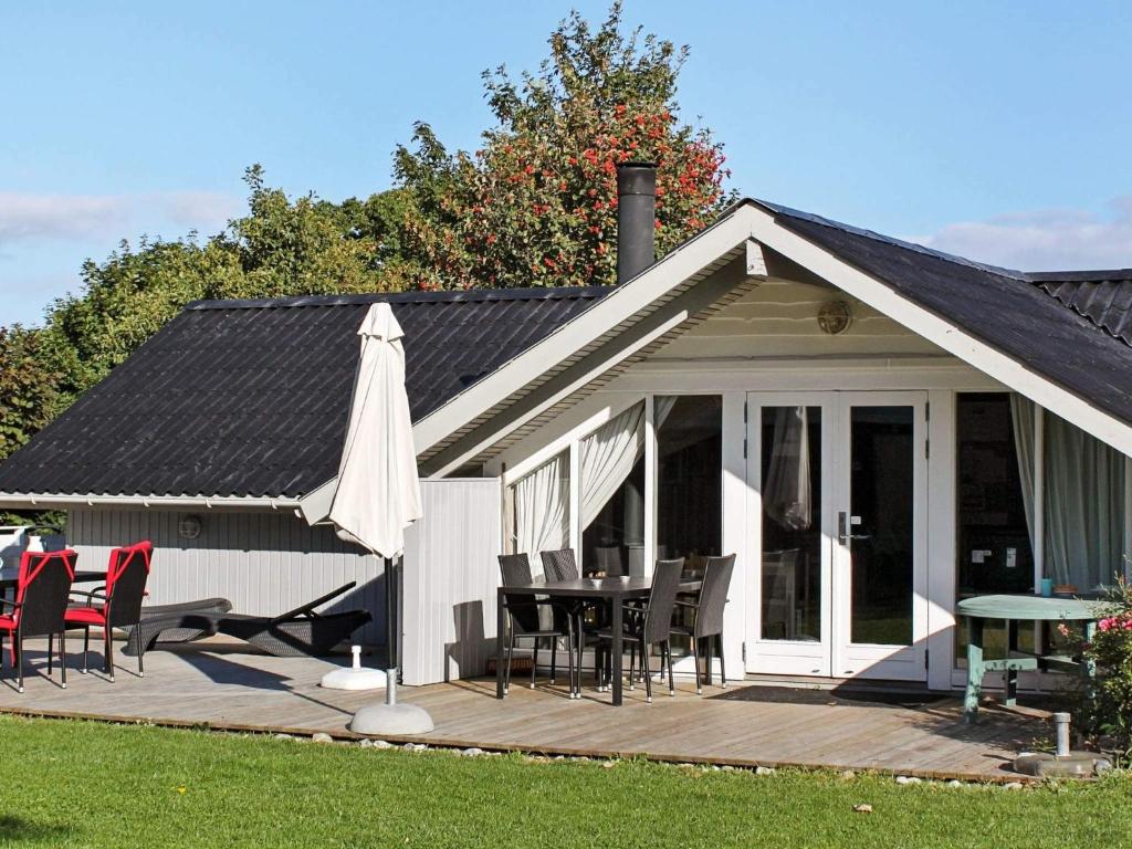 a house with a deck with a table and chairs at 4 star holiday home in Sydals in Sarup
