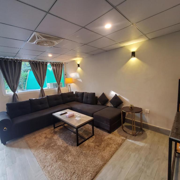 a living room with a blue couch and a table at Private Suite with Private Entrance - Self Check in - F-8 - Private Parking in Islamabad