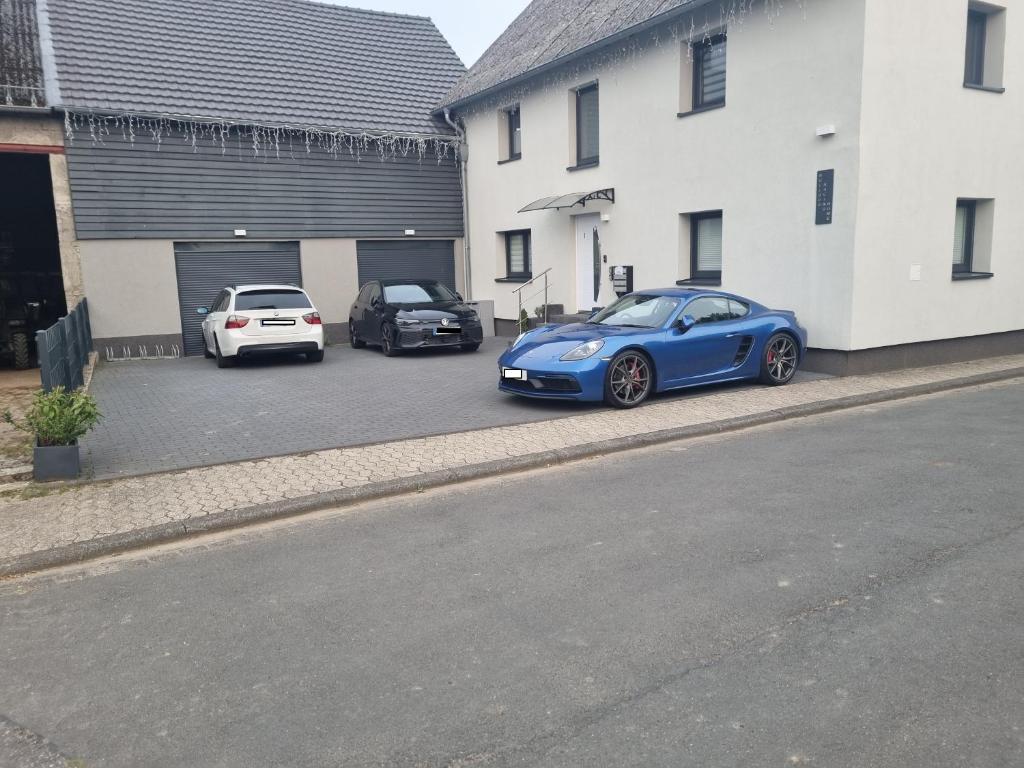 two cars parked in a parking lot next to a building at CJS Apartments - Chill or Drive am Nürburgring, Free Parking, WLan, Spacious Rooms, Quiet Location in Rodder