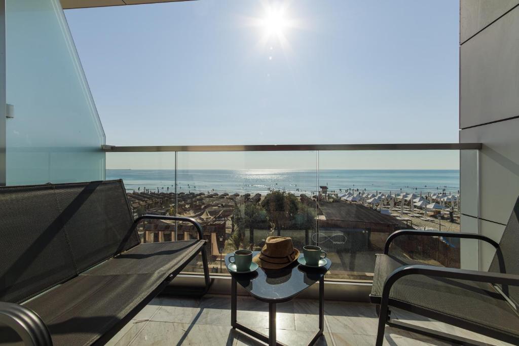 a balcony with a table and a view of a city at Exotic Sunrise View in Infinity Pool & Spa Resort in Mamaia Sat/Năvodari
