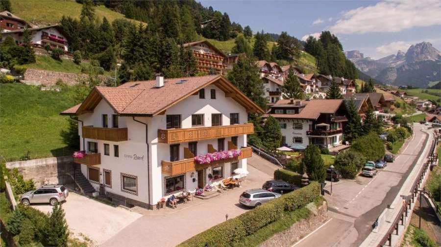 a large white building on the side of a mountain at Hotel Garni Ruscel in Santa Cristina Gherdëina