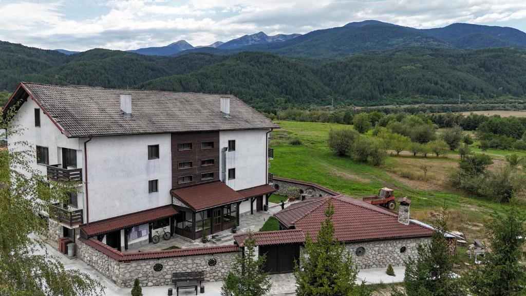an aerial view of a house with mountains in the background at Къща за гости "Тони" in Dobrinishte