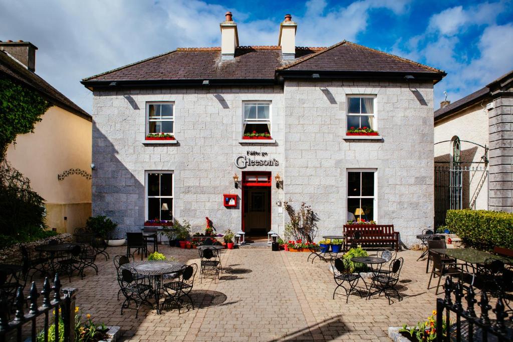 a white building with tables and chairs in front of it at Gleeson's Restaurant & Rooms in Roscommon