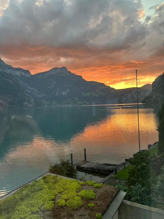 a view of a lake at sunset with mountains at Exclusive Lake Access Villa Studio in Fluelen