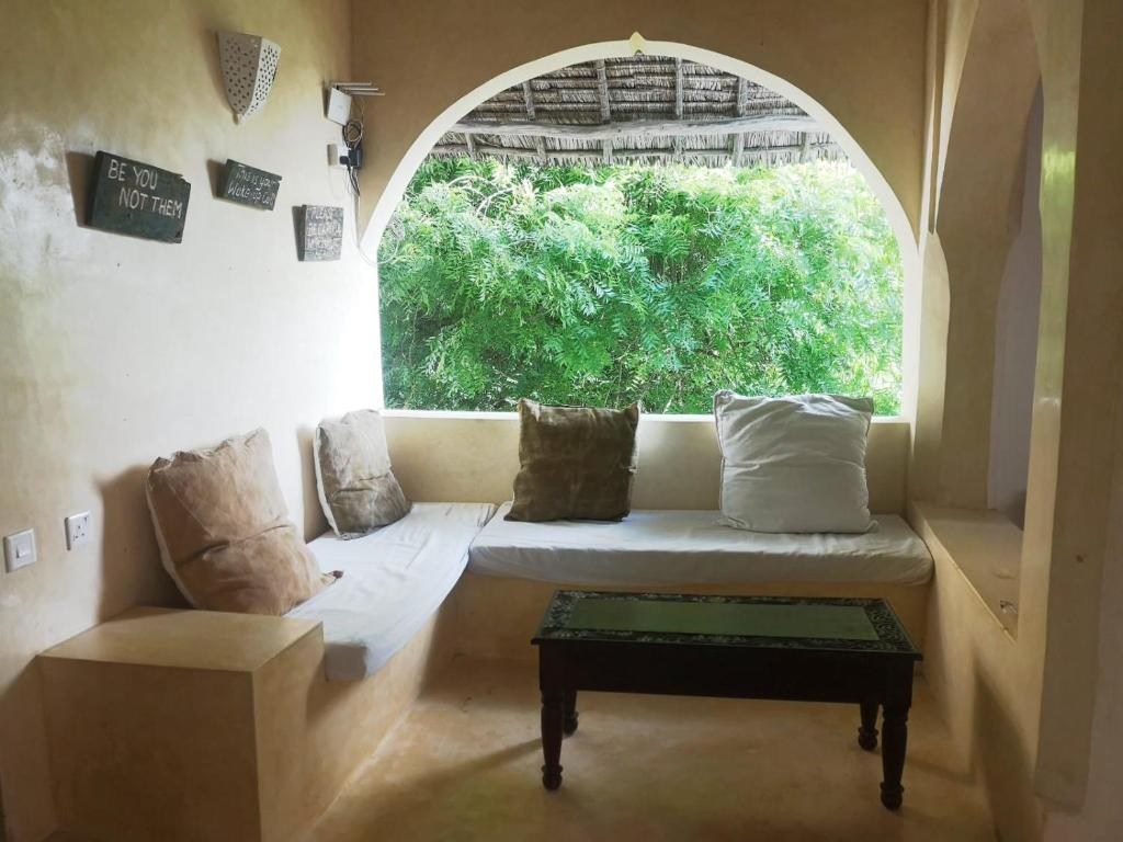 a room with a window with a couch and a table at La Joya Lamu in Shela