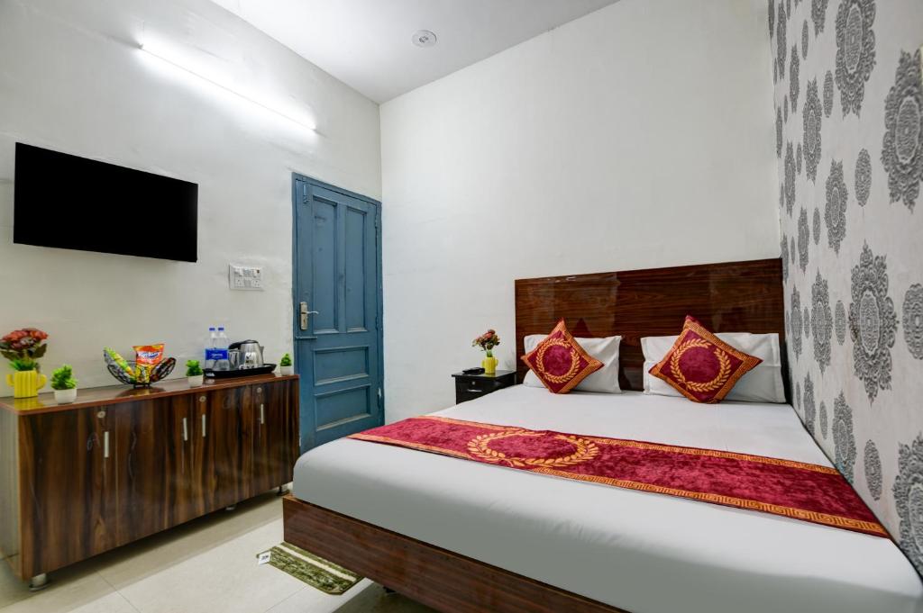 ニューデリーにあるHotel ALLEN STAY Uttam Nagarの大きなベッドとテレビのある寝室
