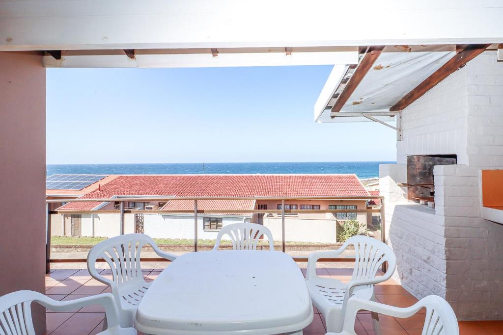 a white table and chairs on a balcony with the ocean at Natspat 14 in Margate