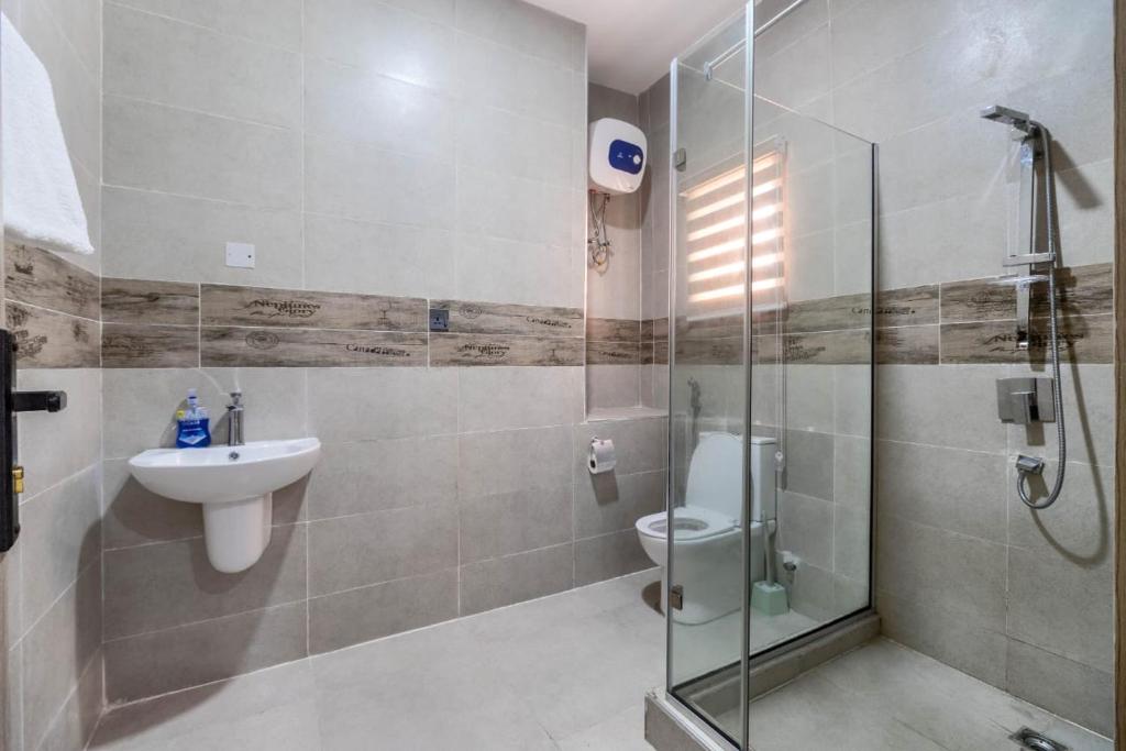 a bathroom with a shower and a sink and a toilet at 3 Bedroom Duplex for Shortlet in Ikota