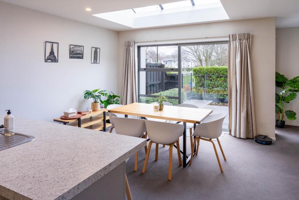 a kitchen and dining room with a table and chairs at The Willows Parkside Retreat in Christchurch