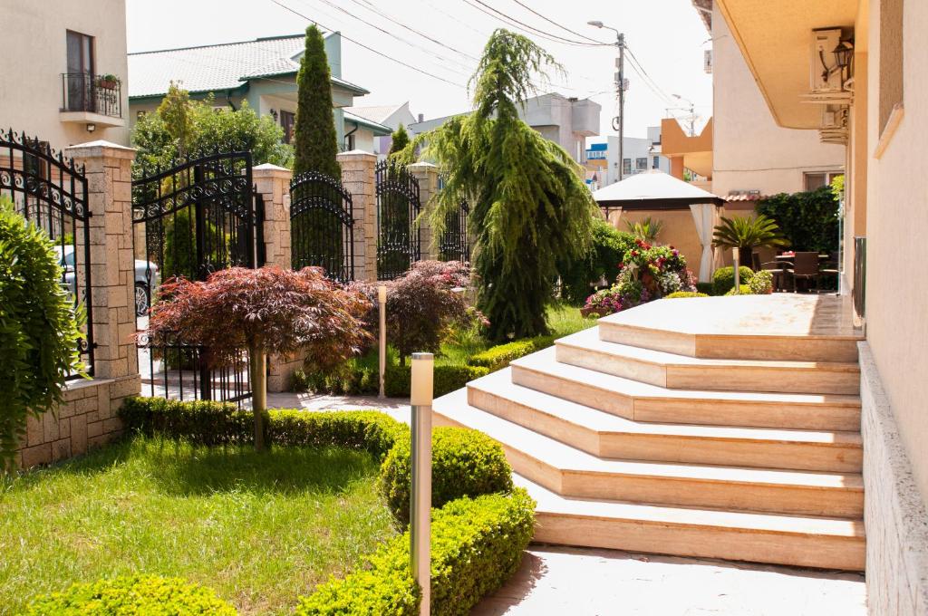 un escalier dans un jardin avec des buissons dans l'établissement Pensiunea Ingrid, à Eforie Nord