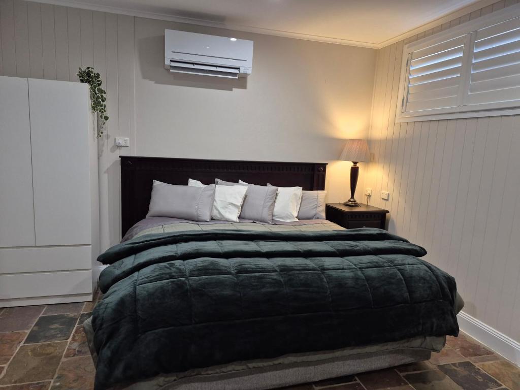 1 dormitorio con 1 cama grande y edredón negro en Reddoor Studio Millthorpe, en Millthorpe
