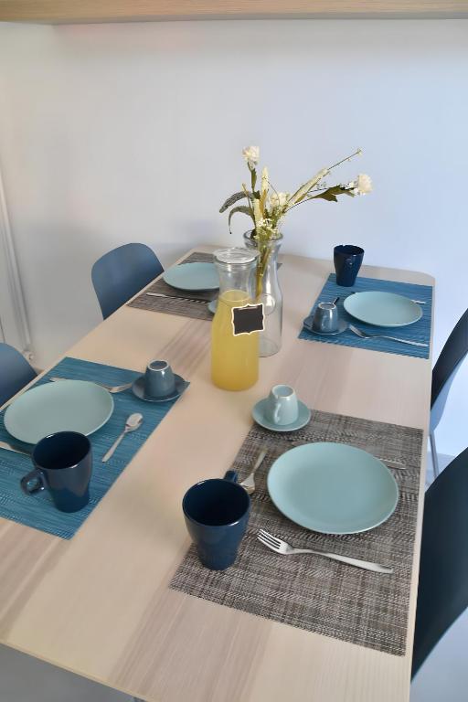 un tavolo con piatti blu e una brocca di succo d'arancia di Appartamento 1m a Fiumaretta di Ameglia