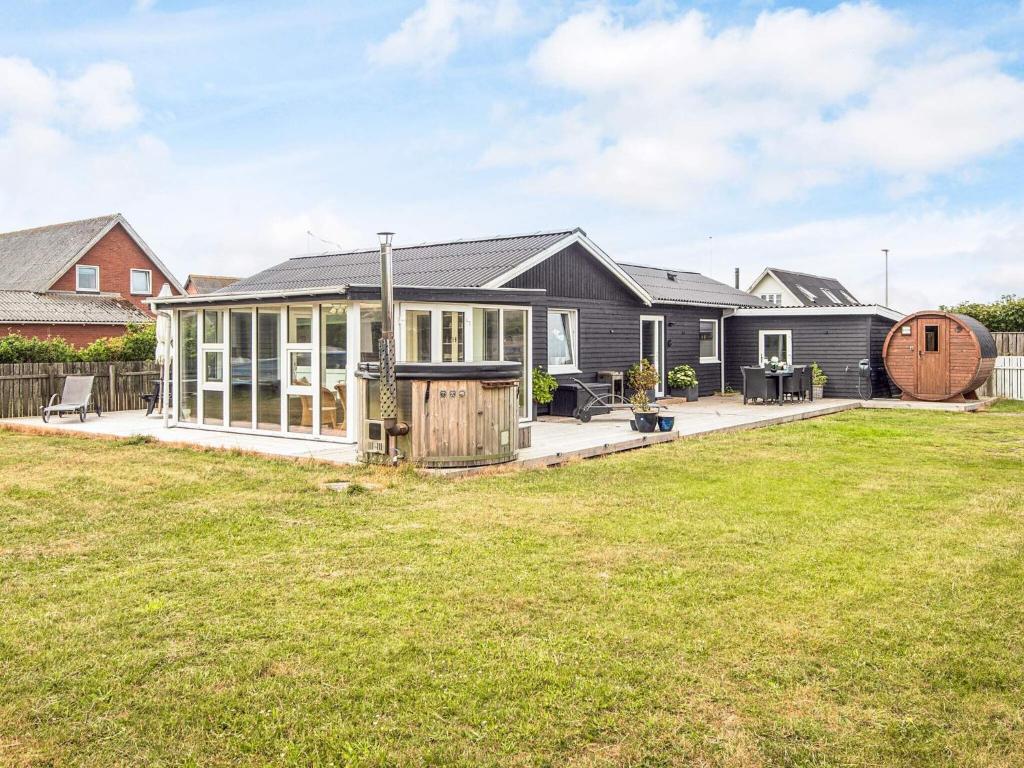 a house with a conservatory and a yard at 4 star holiday home in Ulfborg in Ulfborg