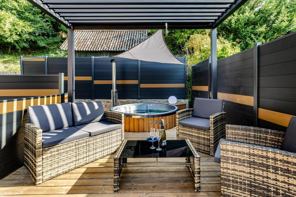 a patio with two wicker chairs and a table at Spa privatif - La Courtisane - Terrasse 40m2 - love-room-alsace-67 in Niederbronn-les-Bains