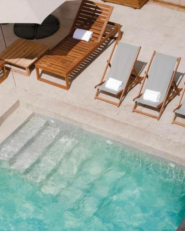 two chairs and a table and a swimming pool at Villa Mediterranea Tossa in Tossa de Mar