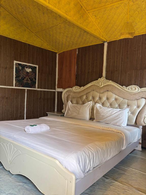 a bed in a room with a large white bed at Tapas Beach Cottage in Calangute