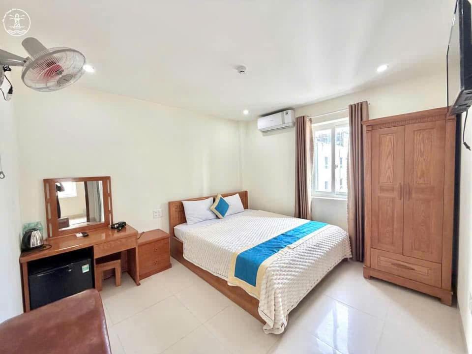 ブンタウにあるAn Khang Hotel Vung tauのベッドと机と鏡のある寝室