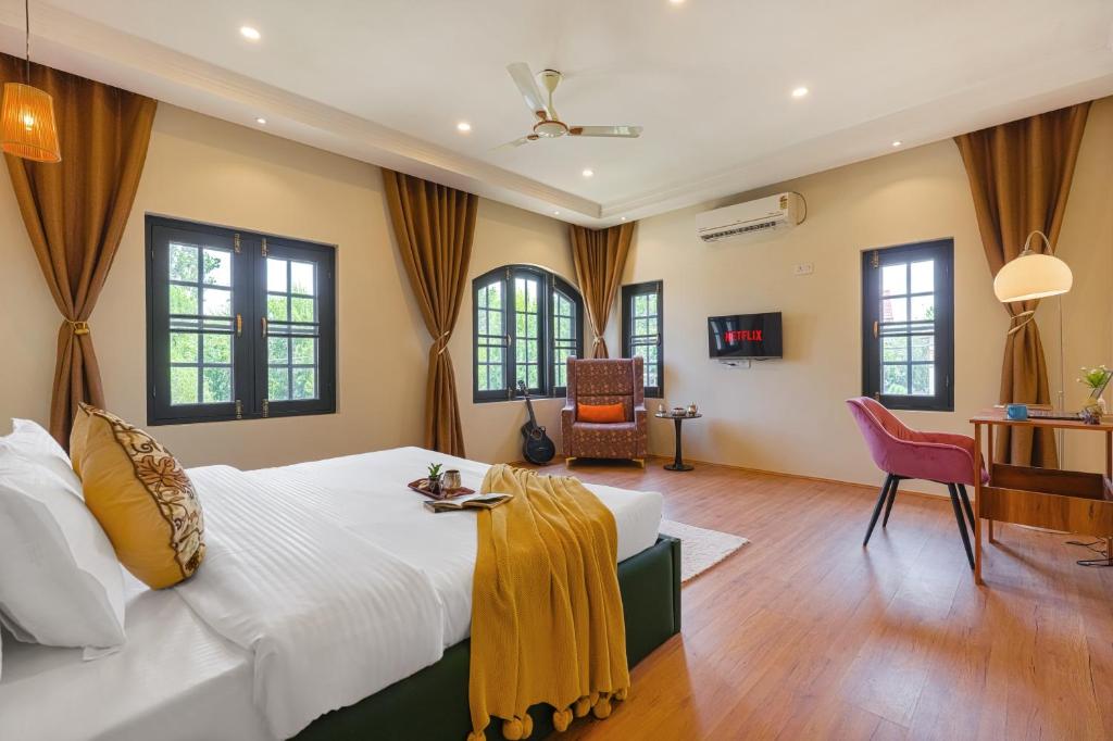 a bedroom with a large white bed and windows at Badakshan Bliss in Srinagar