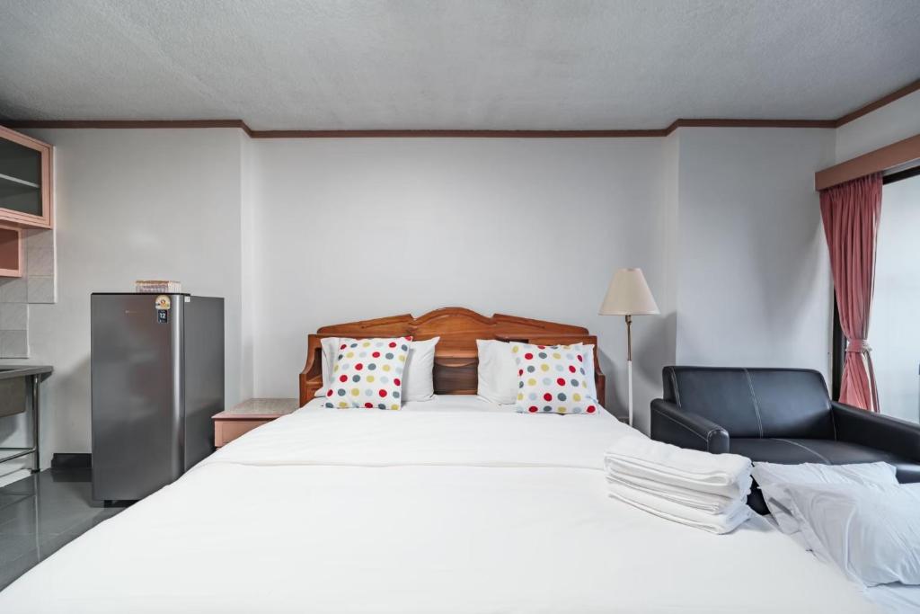 a bedroom with a large white bed and a chair at srivaramansion 1 by cream in Ban Na Song