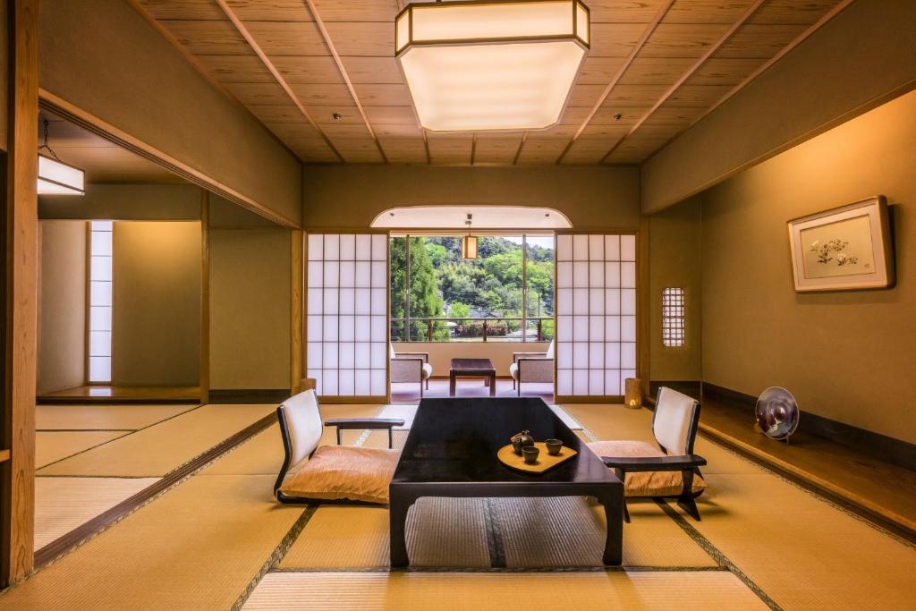 un salon avec une table et des chaises dans l'établissement Ooedo Onsen Monogatari Premium Saiki Bekkan, à Misasa
