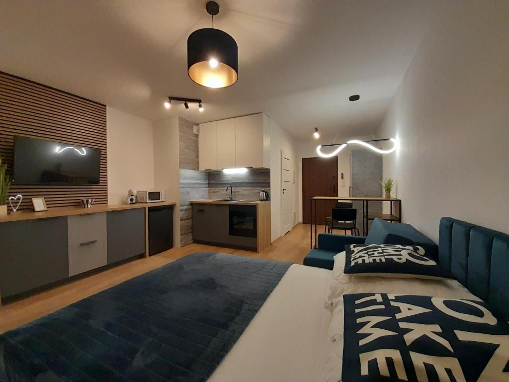 una camera da letto con un letto grande e una cucina con di Apartamenty Idea Centrum Studio z miejscem parkingowym a Radom