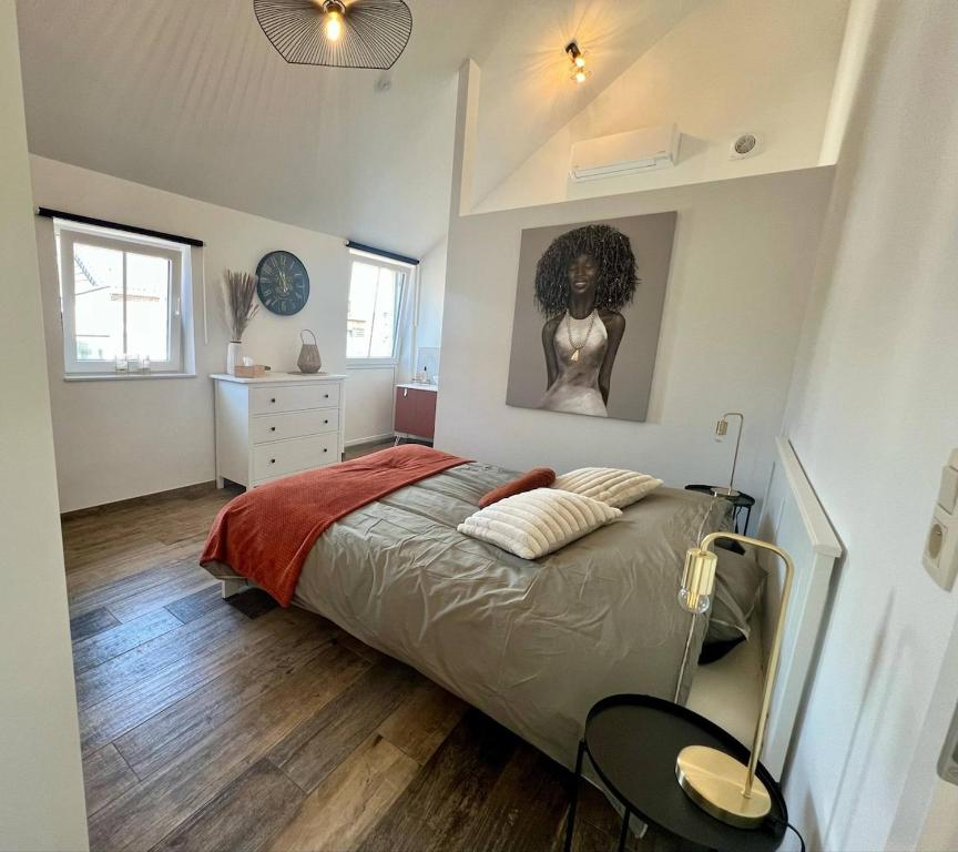 a bedroom with a bed and a picture of a woman at La maison de MiLy in Bassenge