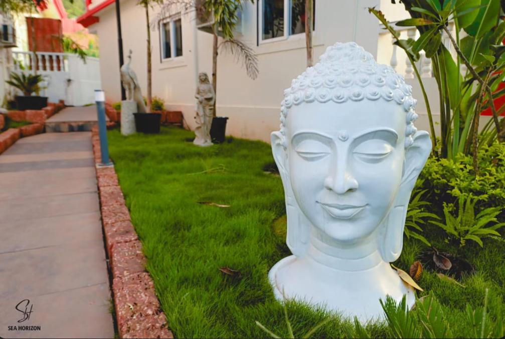 a white statue of a head in the grass at Villa with Pool at Sea Horizon Luxurious Villas in Mandrem