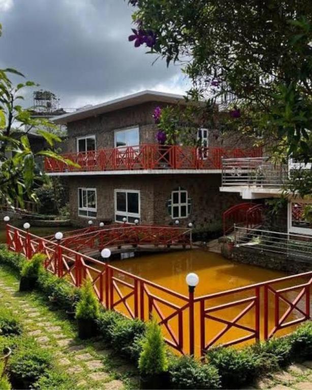 a house with a pond in front of it at Vaga Copper Castle in Vagamon
