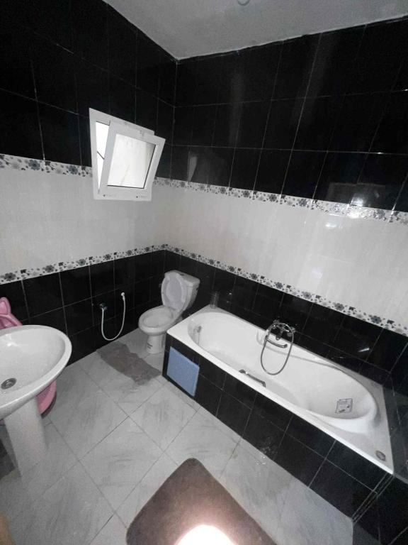 a bathroom with a tub and a toilet and a sink at STUDIO Calm House in Sousse