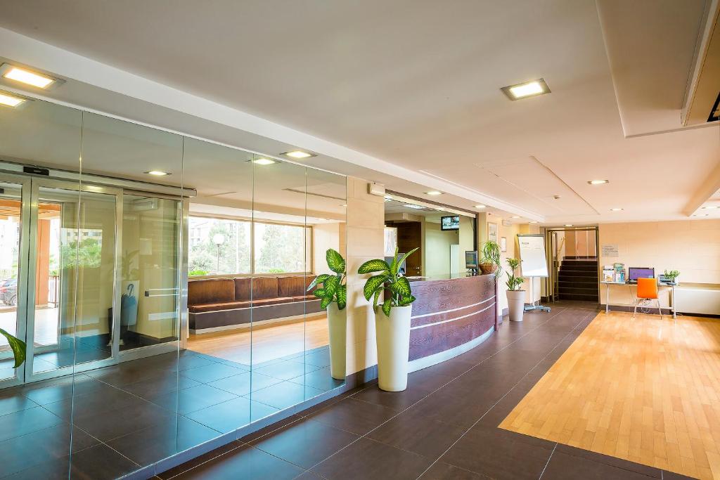 un bureau avec des plantes en pot dans le hall dans l'établissement Hotel Residence Ulivi E Palme, à Cagliari