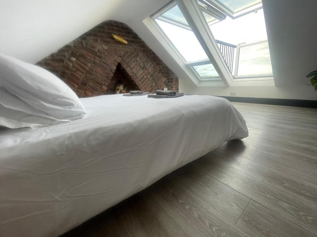 a large bed in a room with a fireplace at Coney View , Porthcawl in Porthcawl