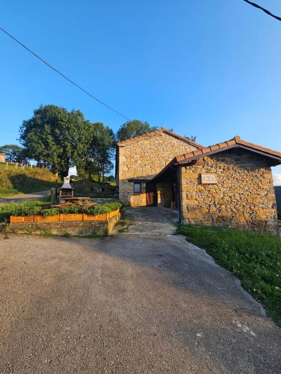 a stone building with a driveway in front of it at La casa de Tio Mines in Regolfo