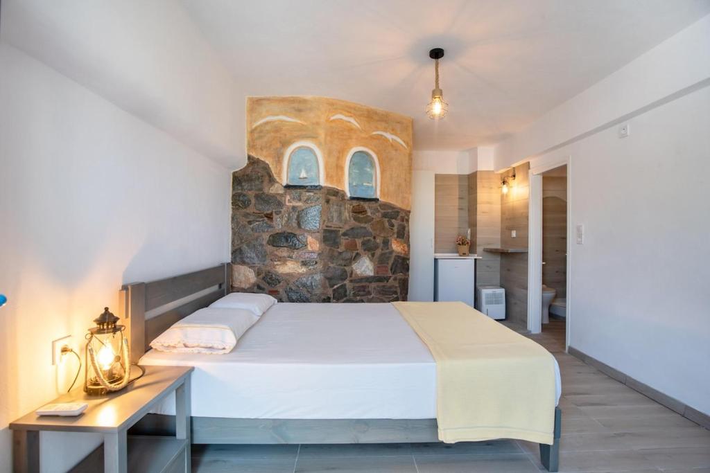 Un dormitorio con una cama grande y una pared de piedra. en Paros apartments Melas b5, en Parikia