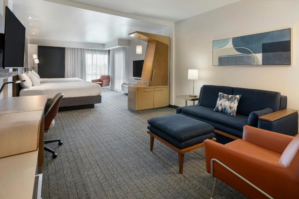 a hotel room with a bed and a living room at Courtyard by Marriott St. Louis St. Peters in Saint Peters