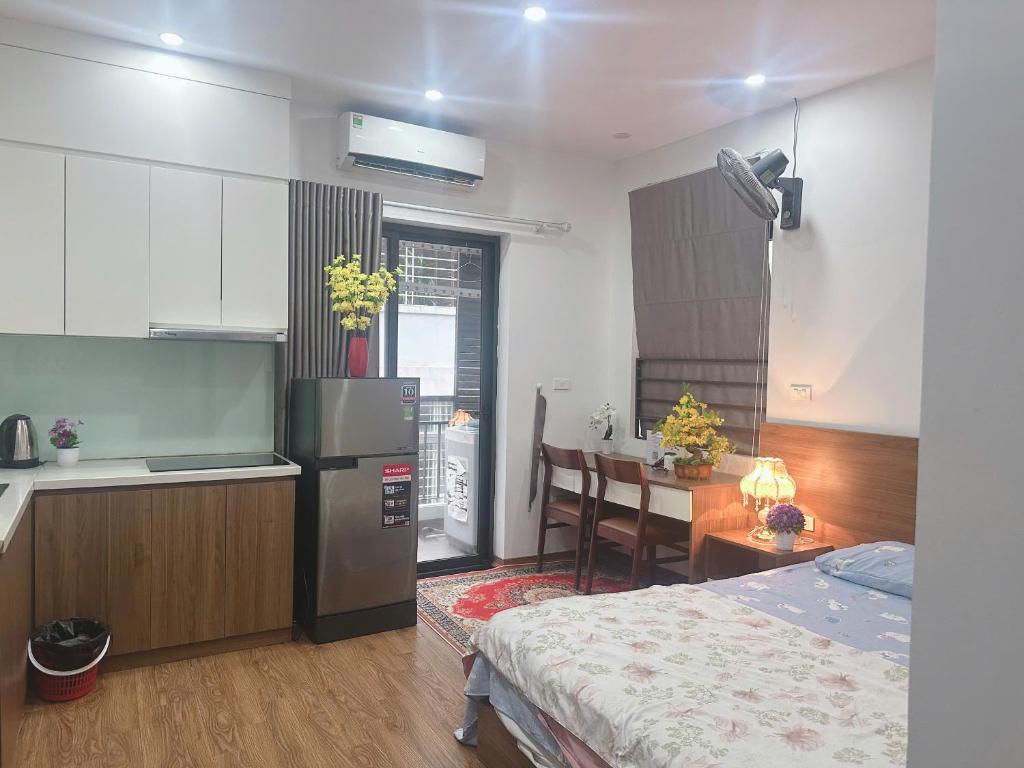 a kitchen and a bedroom with a refrigerator and a table at Trăng Khuyết 404MD in Hanoi