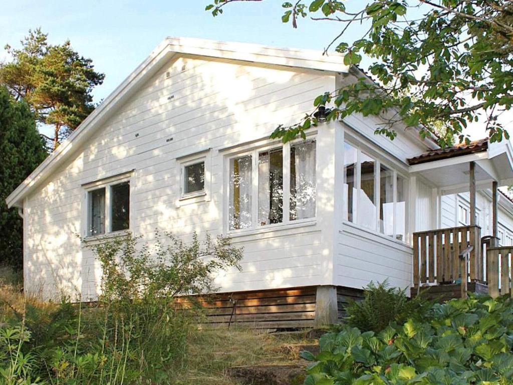 a small white house in a field with trees at 4 person holiday home in UDDEVALLA-By Traum in Sundsandvik