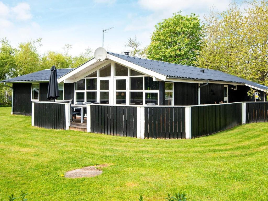 ein Haus mit einem Zaun vor einem Hof in der Unterkunft Luxury Retreat by Fjord - By Traum Ferienwohnungen in Falen