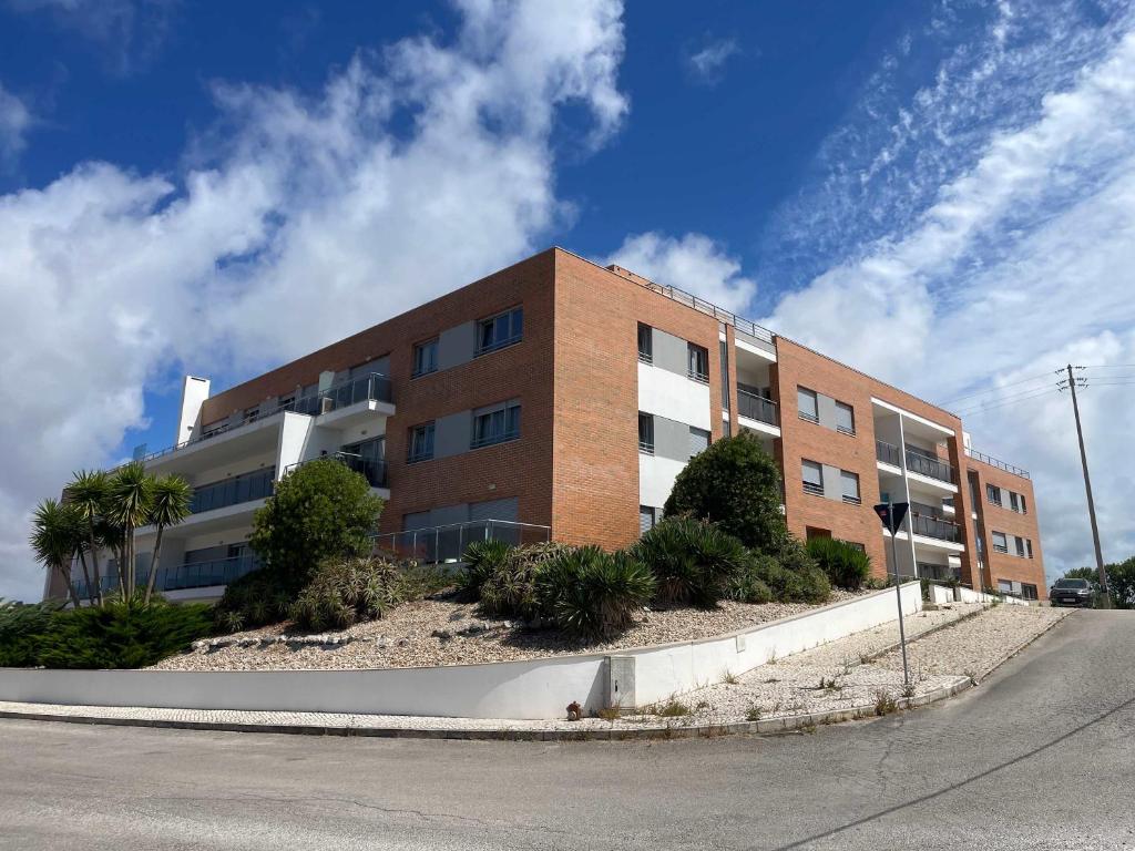 a brick building on the side of a street at Stylish & Spacious Apartment with Balcony in Lourinhã