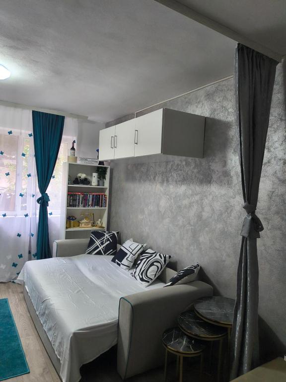 a bedroom with a white bed and a couch at Home MARIA in Orşova