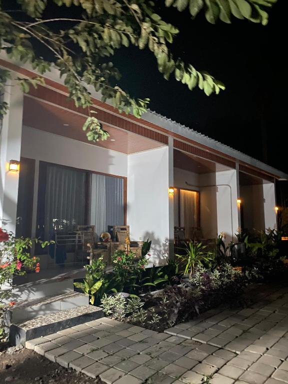 a house with a patio in front of it at night at Raya Homestay in Kuta Lombok